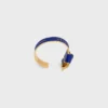 Celine Ribbon Knotted Cuff in Enamel and Brass with Gold Finish Celine Ribbon Knotted Cuff in Enamel and Brass with Gold Finish