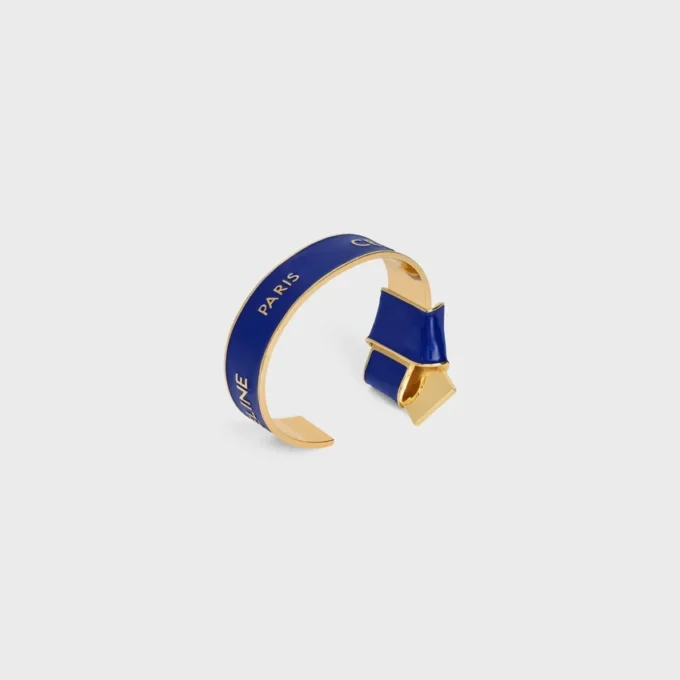 Celine Ribbon Knotted Cuff in Enamel and Brass with Gold Finish Celine Ribbon Knotted Cuff in Enamel and Brass with Gold Finish